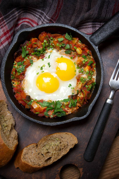 istock Country style fried eggs with vegetable salsa and parsley 873423128