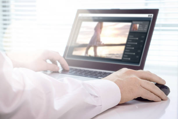 istock Photo editing. Professional editor retouching an image with laptop and imaginary software. 873462506