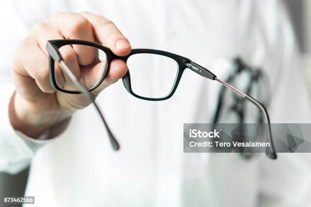 Optician Giving New Glasses To Customer For Testing And Trying Eye Doctor Showing Patient Lenses Stock Photo - Download Image Now