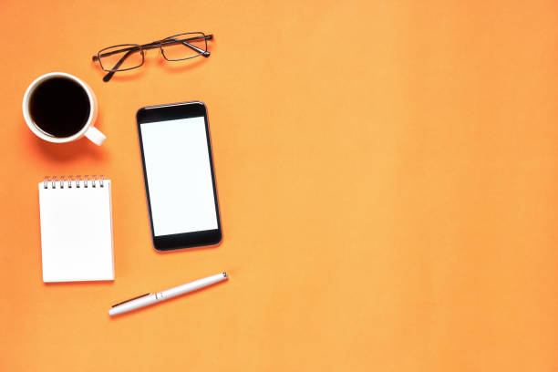 istock Top view, Modern workplace with notbook and pen with smart phone placed on white background. Copy space suitable for use in graphics. 873473524