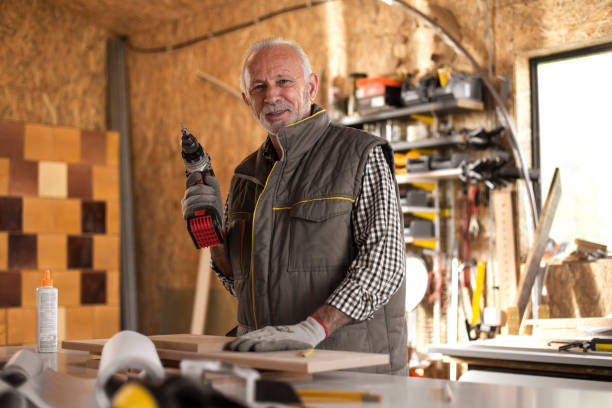 istock Mature carpenter in workshop holding cordless drill 873477180