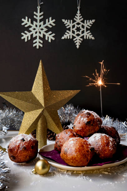 traditionelle holländische oliebollen, öl knödel oder krapfen mit holzlöffel für silvester mit wunderkerze - sparkel stock-fotos und bilder