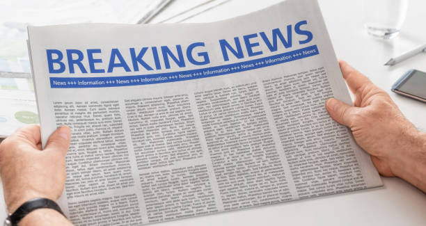 istock Man reading newspaper with the headline Breaking News 873504662