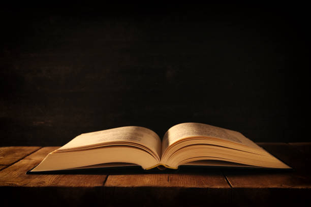 istock image of open antique book on wooden table 873507490