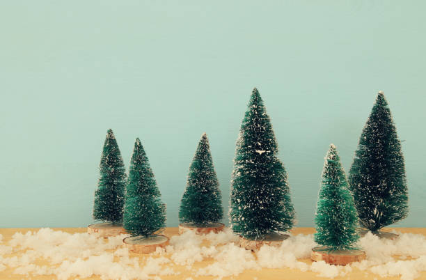 istock Image of christmas trees on snowy wooden table. 873507550