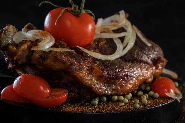 istock Fried lamb with vegetables. Fried meat on a black background 873508288