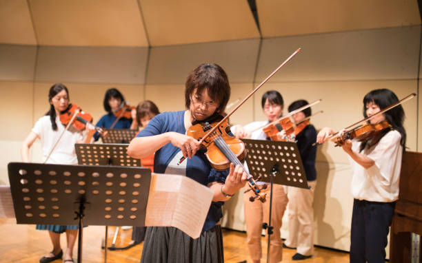 istock Group of people playing violin at concert hall 873508318
