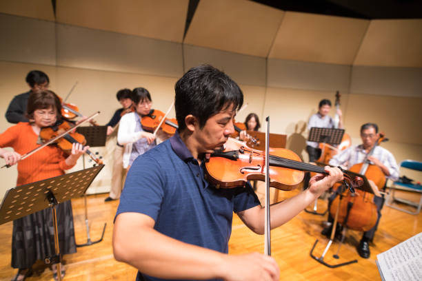 istock Group of people playing violin at concert hall 873508406