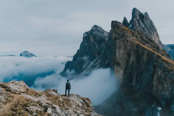 Young Caucasian man  hiking near Seceda mountain in Dolomites