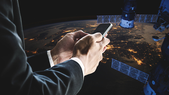 Businessman using mobile smart phone with space satellite. Elements of this image are furnished by NASA