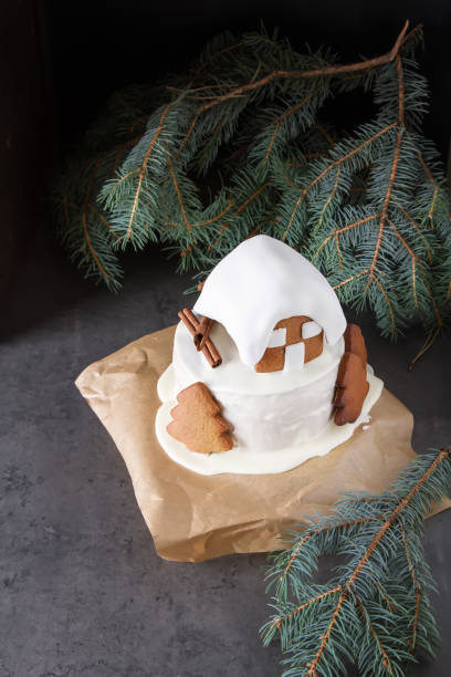 New Year cake with Christmas trees and gingerbread houses and cinnamon. Dark background.