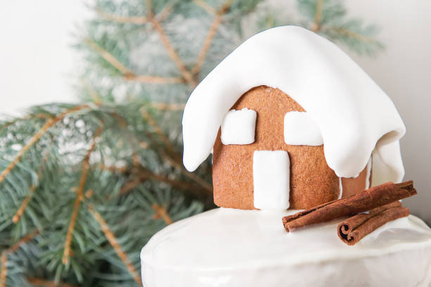 New Year cake with Christmas trees and gingerbread houses and cinnamon. Light background.