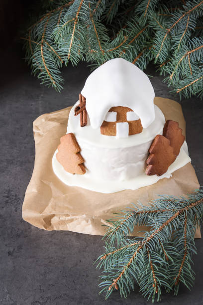 New Year cake with Christmas trees and gingerbread houses and cinnamon. Dark background.