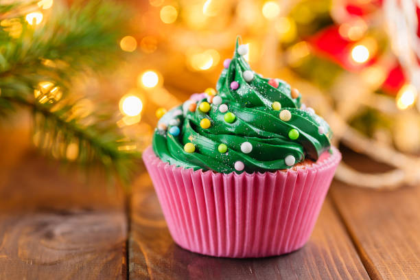 istock Green christmas cupcake with bokeh on background 873515748
