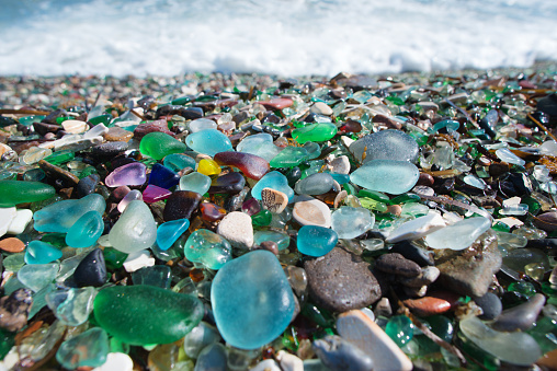 Beach fully covered with multicolored glass pebble. Wonder of nature.