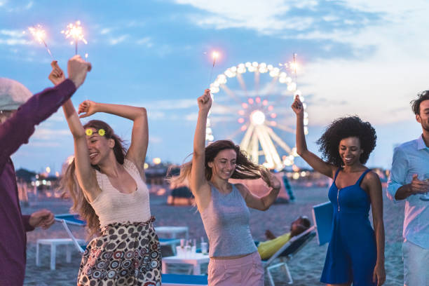 istock Happy friends making beach party after sunset with fireworks and drinking champagne - Young people having fun dancing outdoor  - Soft focus on center girl face - Youth and festival concept 873526836