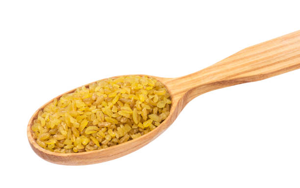 istock Dry bulgur wheat in wooden spoon isolated on white background 873528744