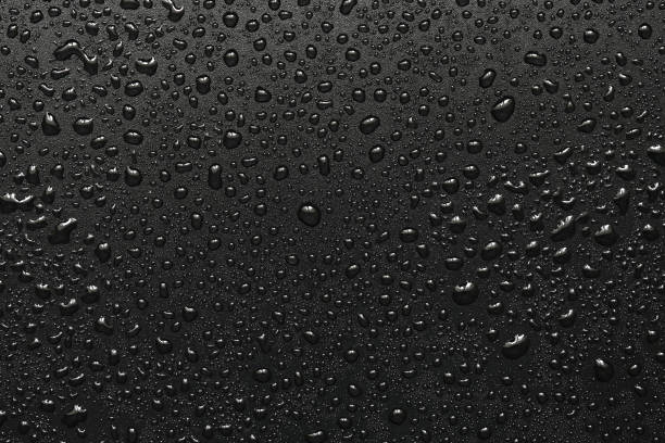 istock Drops of water on a black surface. The condensate. Top view. Free space. 873531236