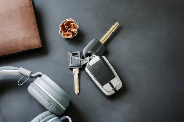 Lifestyle changes of your with stopped work and get out travelling relaxing searching for freedom. above view key car and headphone music and wallet on black table. copy space used for add messages.