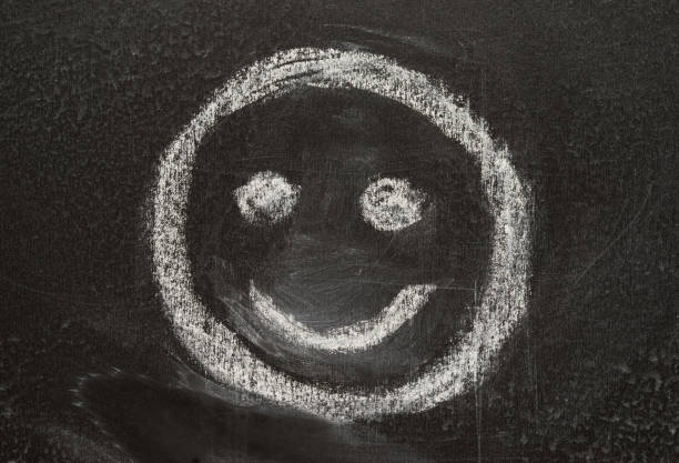 smile sign smiley, sketched with white chalk on the blackboard stock photo