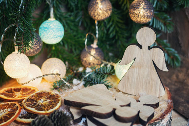 istock Two wooden angels hanging in a Christmas branch 873539340