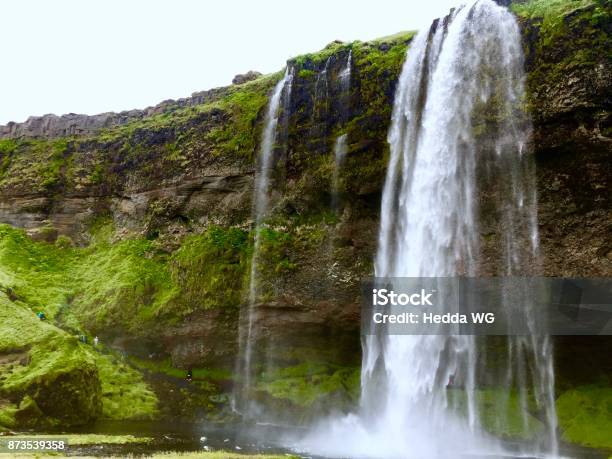 Seljalandsfoss Waterfall In Iceland With People Walking On A Path Behind The Waterfall Stock Photo - Download Image Now