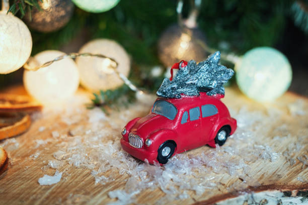 istock Small red car in front of a Christmas branch 873539448
