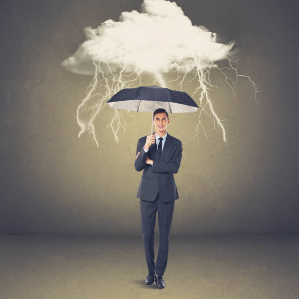 istock Businessman with umbrella under thunderstorm cloud 873539658