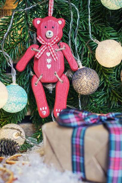 istock Red wooden bear hanging in Christmas branch 873539996