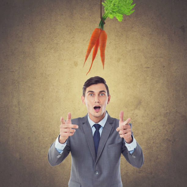 istock Excited businessman with dangling carrots 873557692