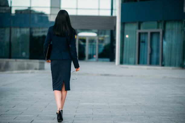 istock Business woman with laptop in hands, back view 873560574