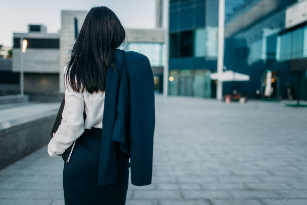 istock Businesswoman with suit in hand, back view 873563122