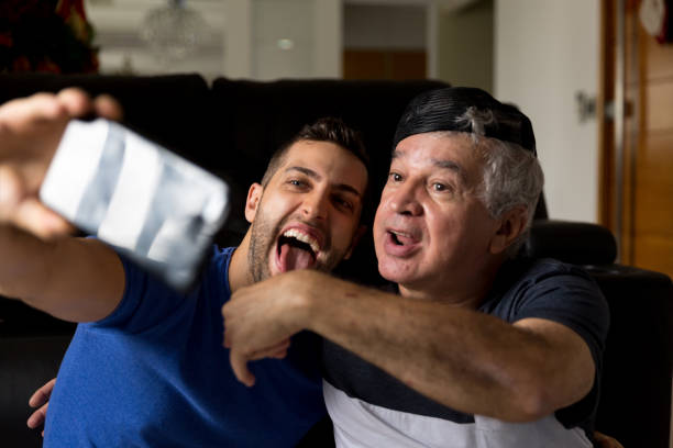 istock Dad and son sharing on social media with smartphone at home 873566216