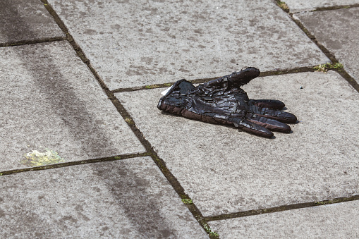 Single discarded glove on the pavement in a street in Edinburgh, Scotland.