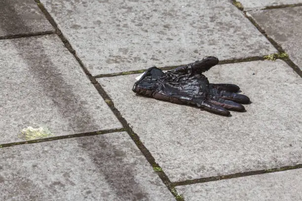 Photo of Single discarded glove on the pavement in a street in Edinburgh, Scotland.