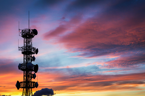 Silhouette of the Antenna on communication system tower with sunset sky background