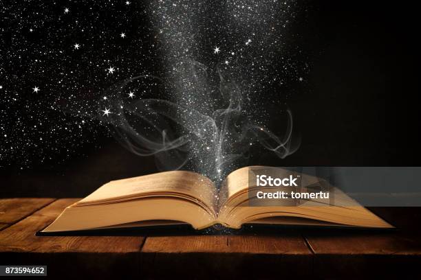 Image Of Open Antique Book On Wooden Table With Glitter Overlay Stock Photo - Download Image Now