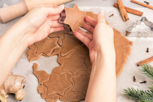 istock Woman hands cut cookies from raw dough. 873597596