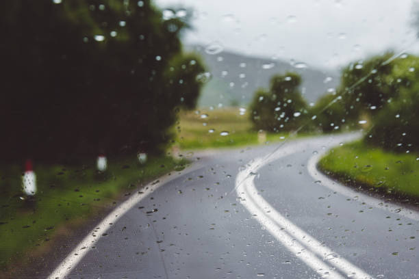Rainy day driving on a single carriageway in slippery conditions blurred out of focus stock photo