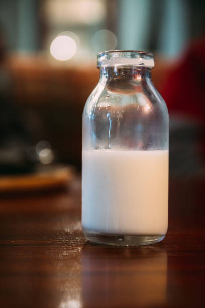 istock old style milk cream bottle on a table, portrait orientation, half empty 873601880
