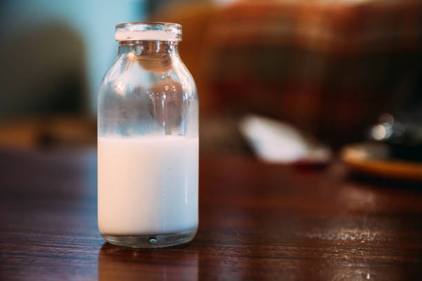 istock old style milk cream bottle on a table, landscape orientation, half empty 873604734