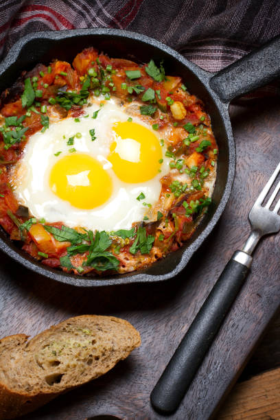 istock Country style fried eggs with vegetable salsa and parsley 873616170