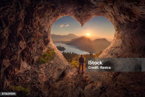 Young Woman In Heart Shape Cave Towards The Idyllic Sunrise Stock Photo - Download Image Now