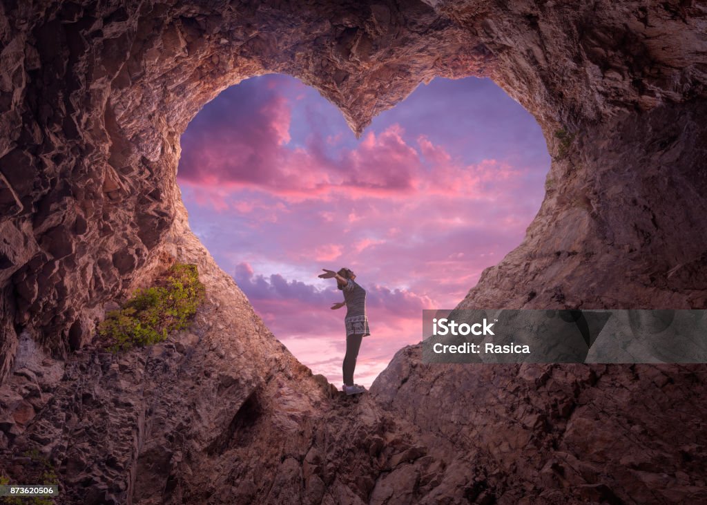 Jovem no coração forma caverna em direção ao céu bonito - Foto de stock de Amor royalty-free