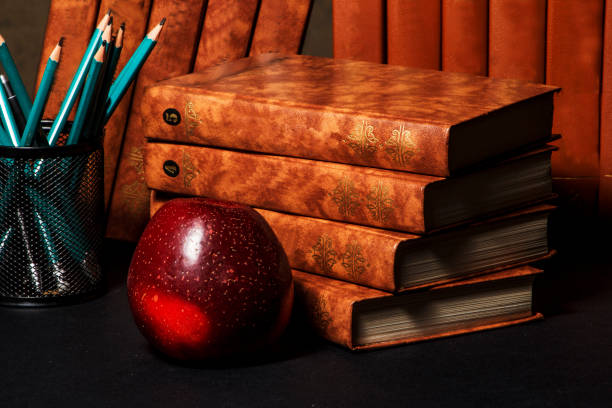 istock Books with an apple on a table with pencils. 873620666