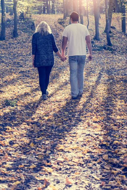 istock Young couple on a walk at autumn park 873623330