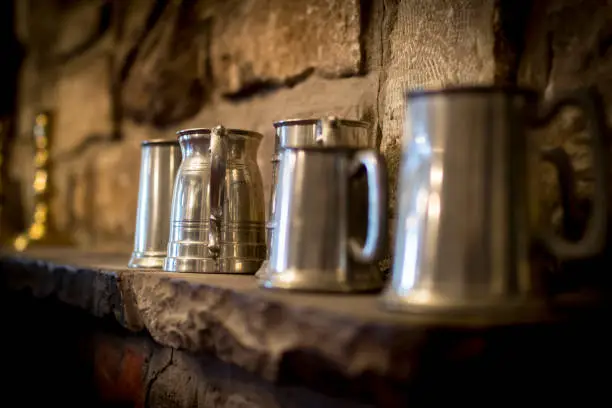 Traditional pewter tankard in a traditional English pub on a stone shelf