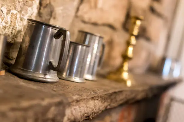 Traditional pewter tankard in a traditional English pub or public house on a stone shelf