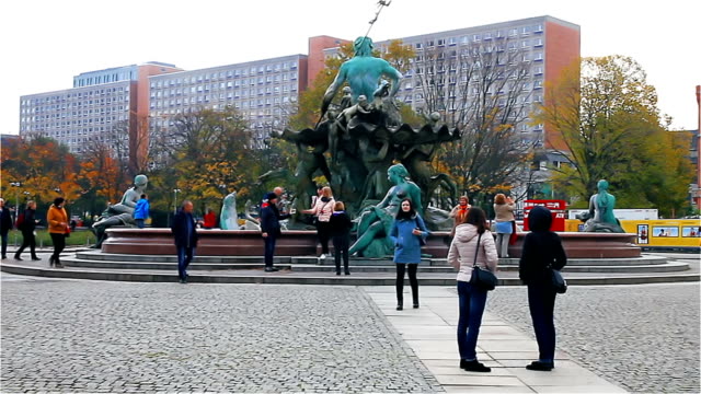 Berlin - November 2017: Tourists strolling along Alexanderplatz near the monument to Neptune