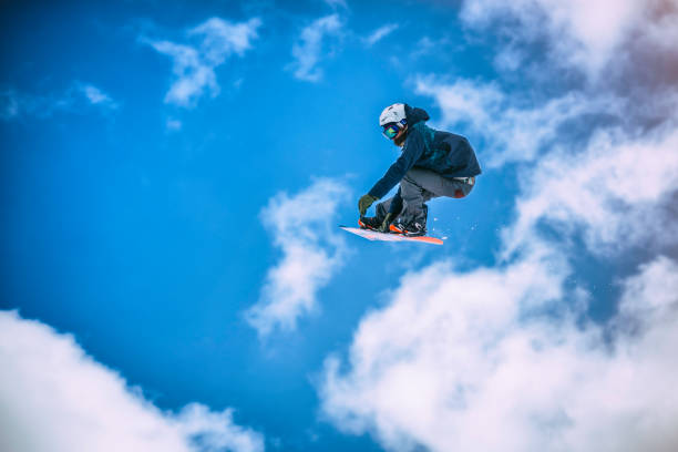 istock Snowboarder in mid-air on partially cloudy backdrop 873624834